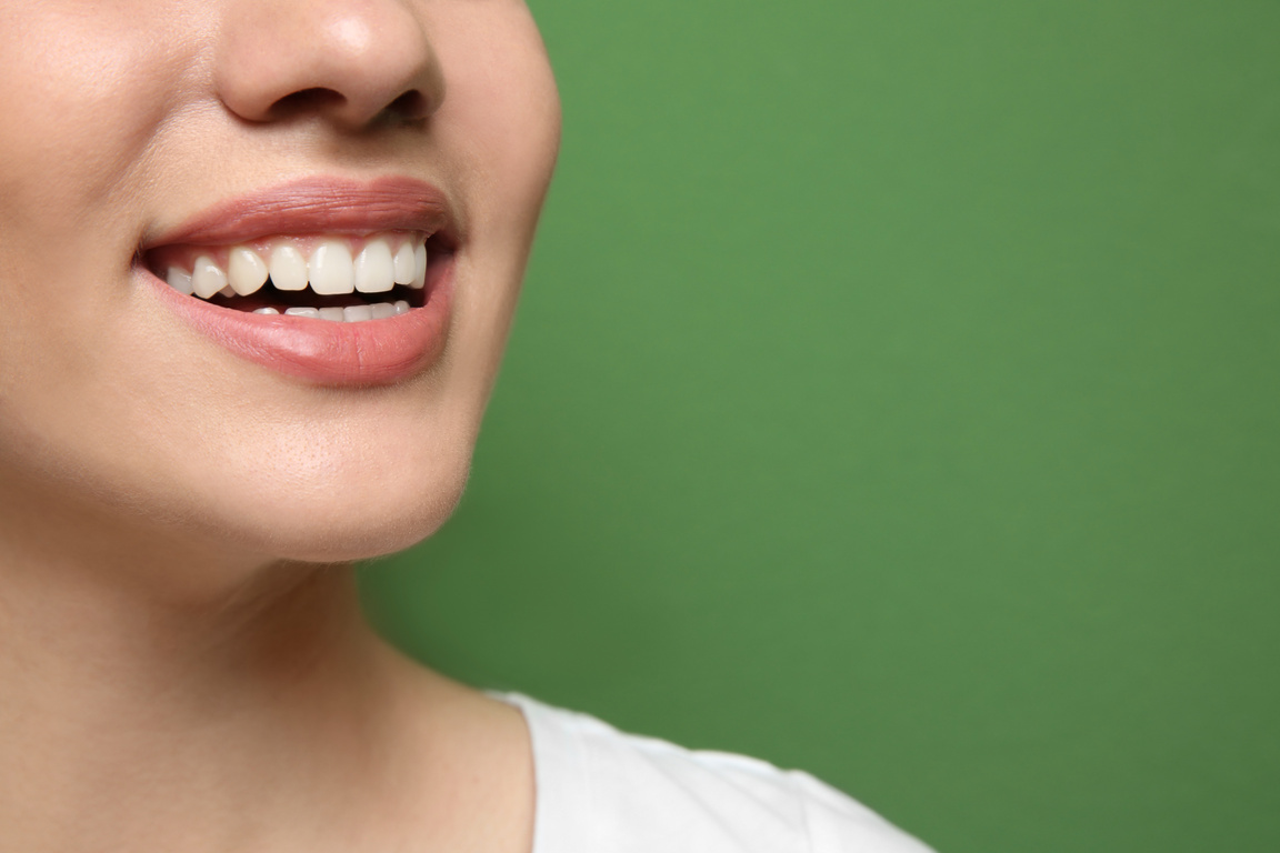 Young Beautiful Woman Smiling on a Green Background